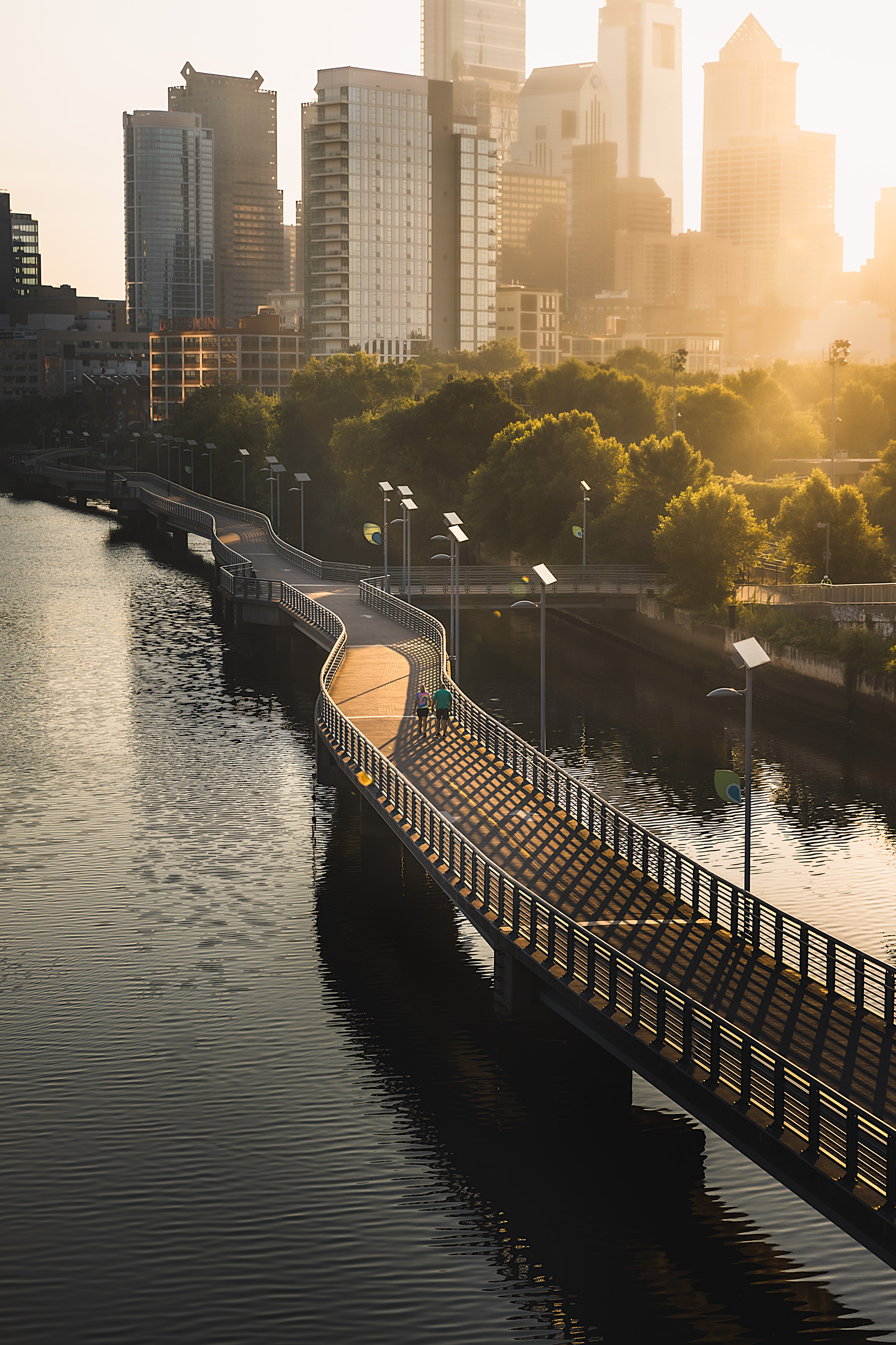 Philadelphia skyline from South Street Bridge at sunrise with people walking